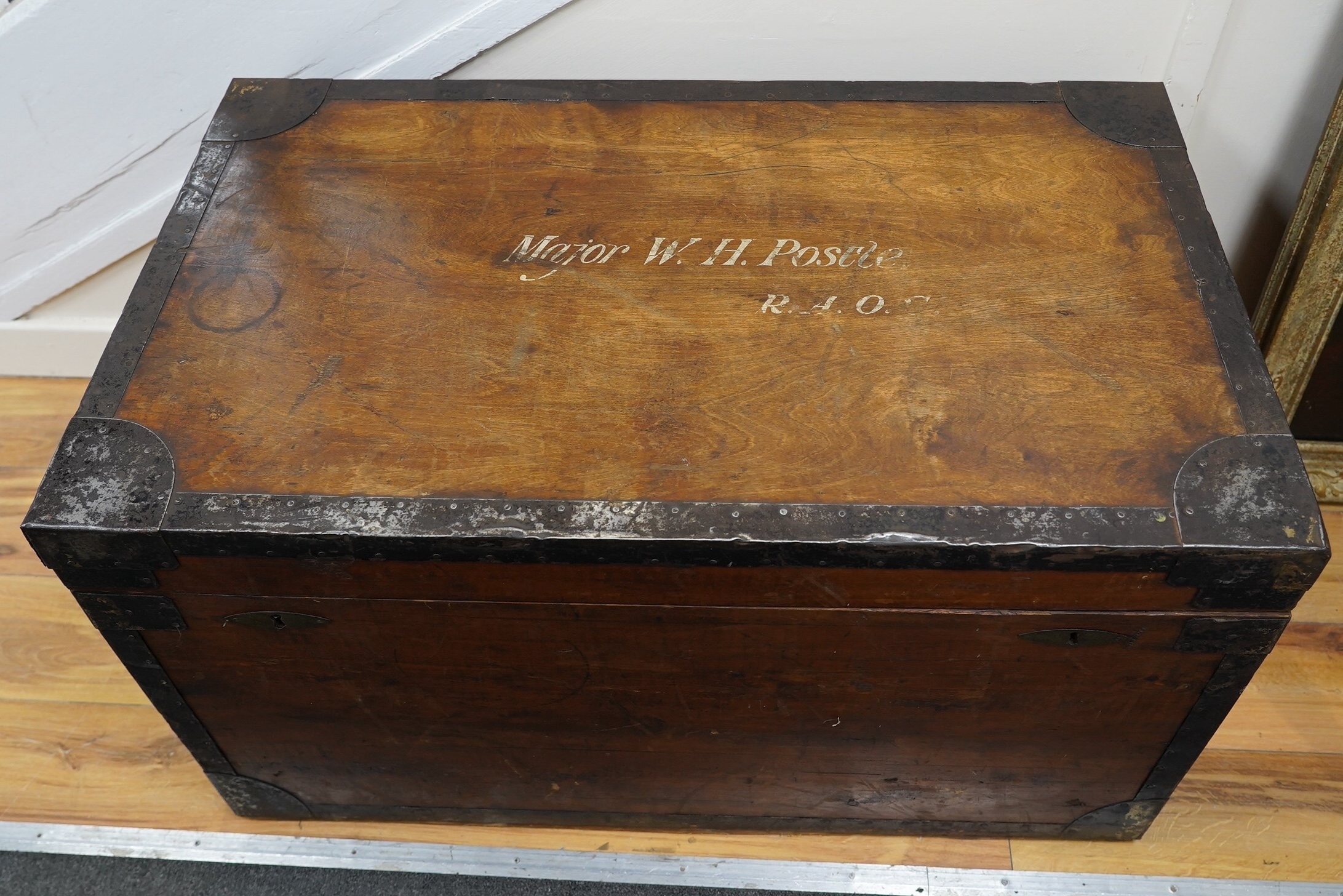A pine military trunk with steel banding to all edges and corners, and original tin lining, owner’s name painted to the lid; ‘Major W.H. Postle R.A.O.C.’, 91.5cm wide, 54cm deep, 53cm high. Condition - fair to good